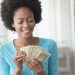 African American woman counting money in living room