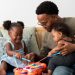 A man plays with his daughters on a xylophone toy